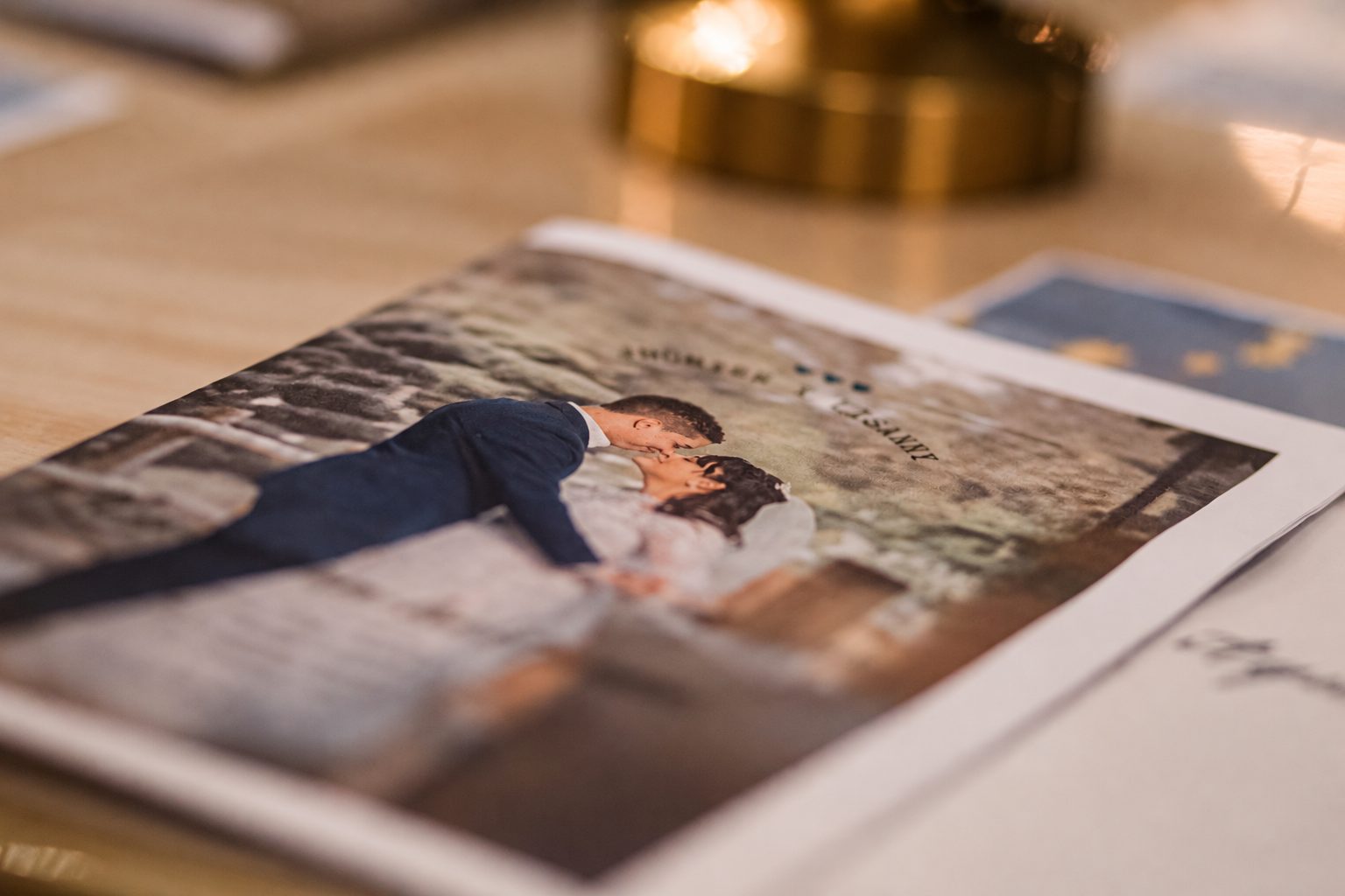 Detalle de una celebración: invitación con la foto de los novios sobre la mesa